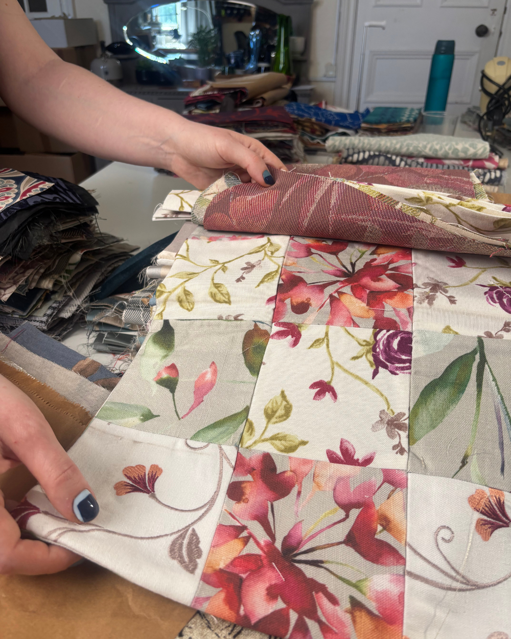 A person holding a piece of textiles in their hands. It appears to be an old curtain.