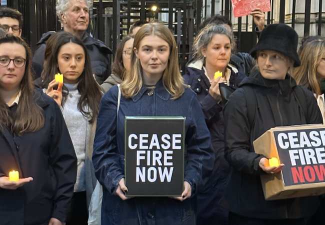 A group of people stand outside Downing Street looking downcase