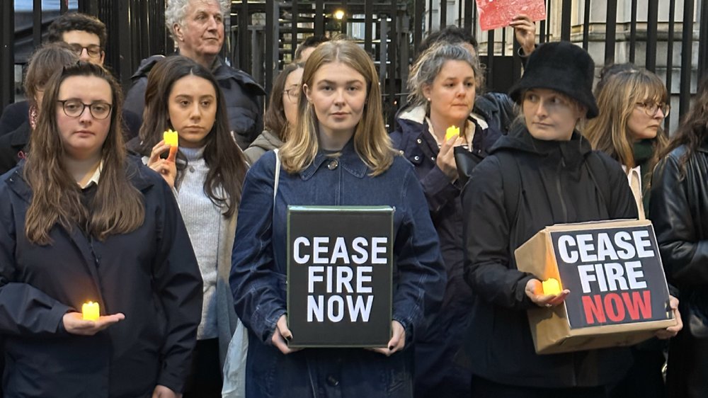 A group of people stand outside Downing Street looking downcase
