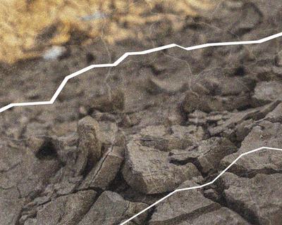 Close-up of dry, cracked earth with white contour lines overlaid, highlighting the uneven surface and texture of the ground.