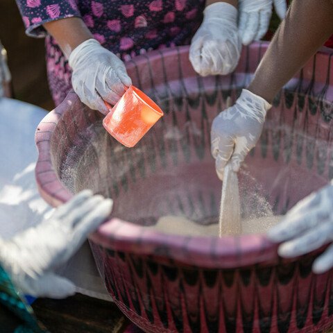 Magdalene Bangura, the leader of Female Pastors Network (FEMINET) leads the gari making process at her home in Sierra Leone.