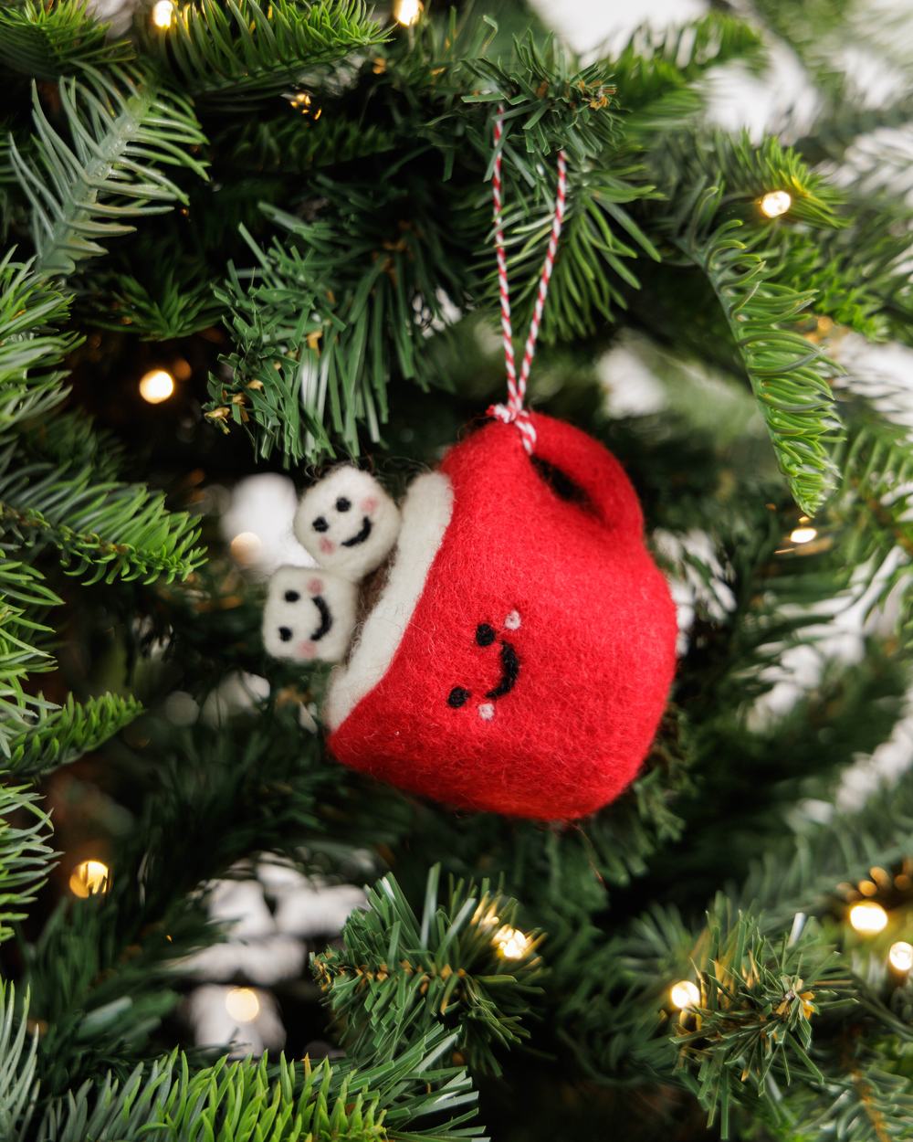 Christmas tree decoration of red felted smiling mug with mini felted smiling marshmallows.