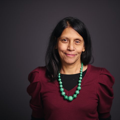 Woman with long hair wearing a bead necklace