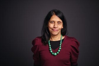 Woman with long hair wearing a bead necklace