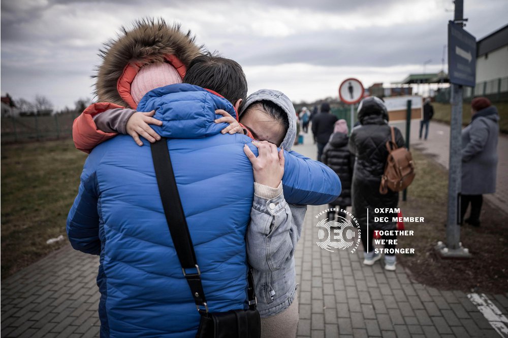 A man hugs his daughter and grandaughter after they crossed the border from Ukraine to Medyka in Poland. Image: Michael Kappeler/dpa