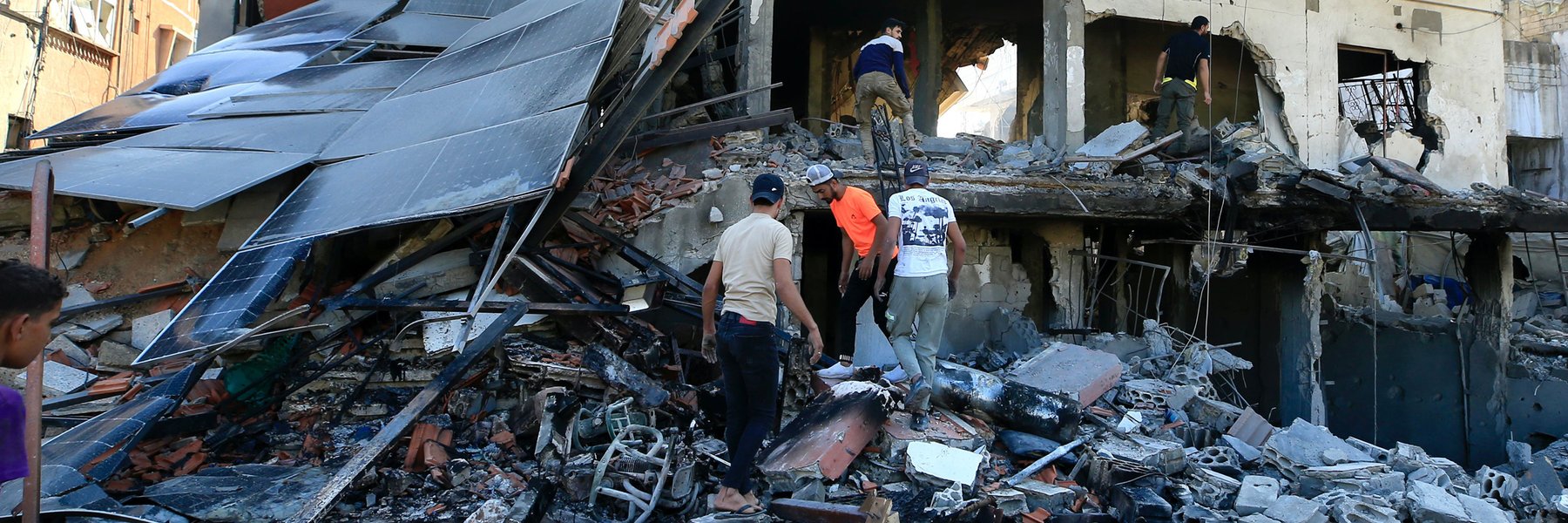 Five people searching through the remains of a bombed out building in Lebanon.