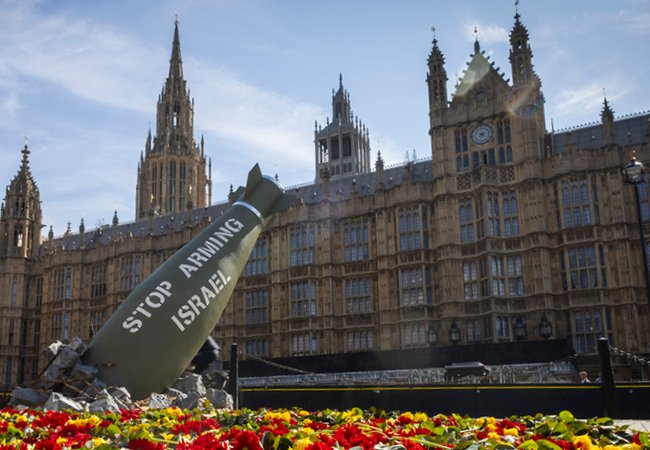 Replica bomb and flowers placed outside UK Parliament for an Oxfam media stunt.
