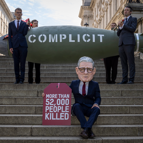 Oxfam’s ‘Keir Starmer’ Big Head appeared outside the UK Parliament placing a gift tag reading “More than 52,000 people killed” on a 16-foot replica MK-84 bomb marked “Complicit” on 12 May 2025, in London United Kingdom.