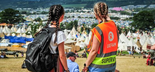 Oxfam volunteer festival steward giving directions at Glastonbury Festival