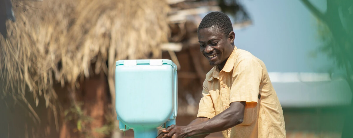 Augustin washes his hands at one of new hand washing kits installed by Oxfam in Kisalaba site. Photo: Arlette Bashizi/Oxfam