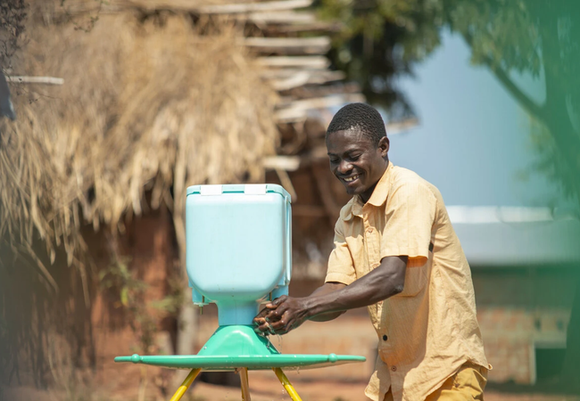 Augustin washes his hands at one of new hand washing kits installed by Oxfam in Kisalaba site. Photo: Arlette Bashizi/Oxfam