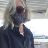 A picture of Clare Coffey wearing sunglasses and a large cloth mask