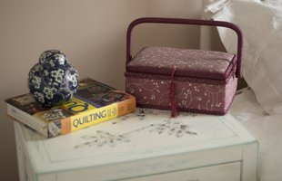 A book on quilting, sewing box and vase