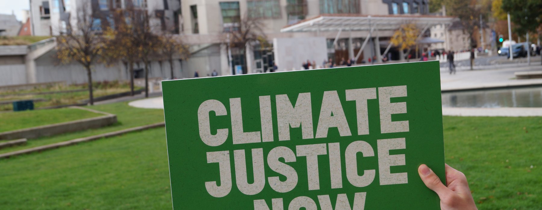 Board reading climate justice now held in front of Scottish Parliament