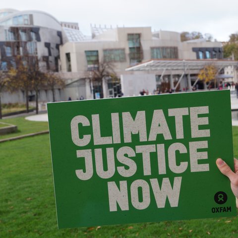 Board reading climate justice now held in front of Scottish Parliament