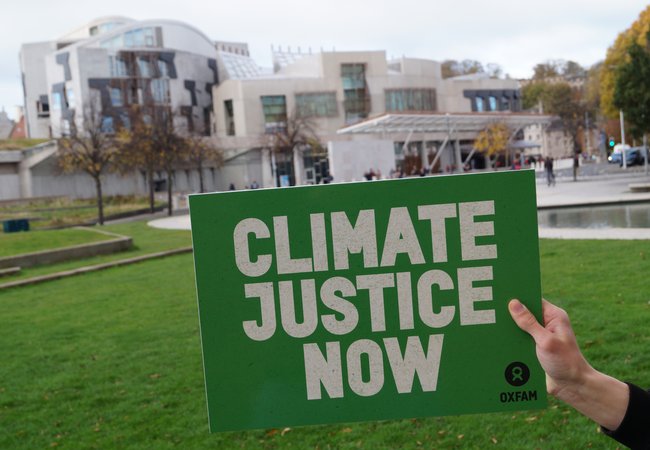 Board reading climate justice now held in front of Scottish Parliament