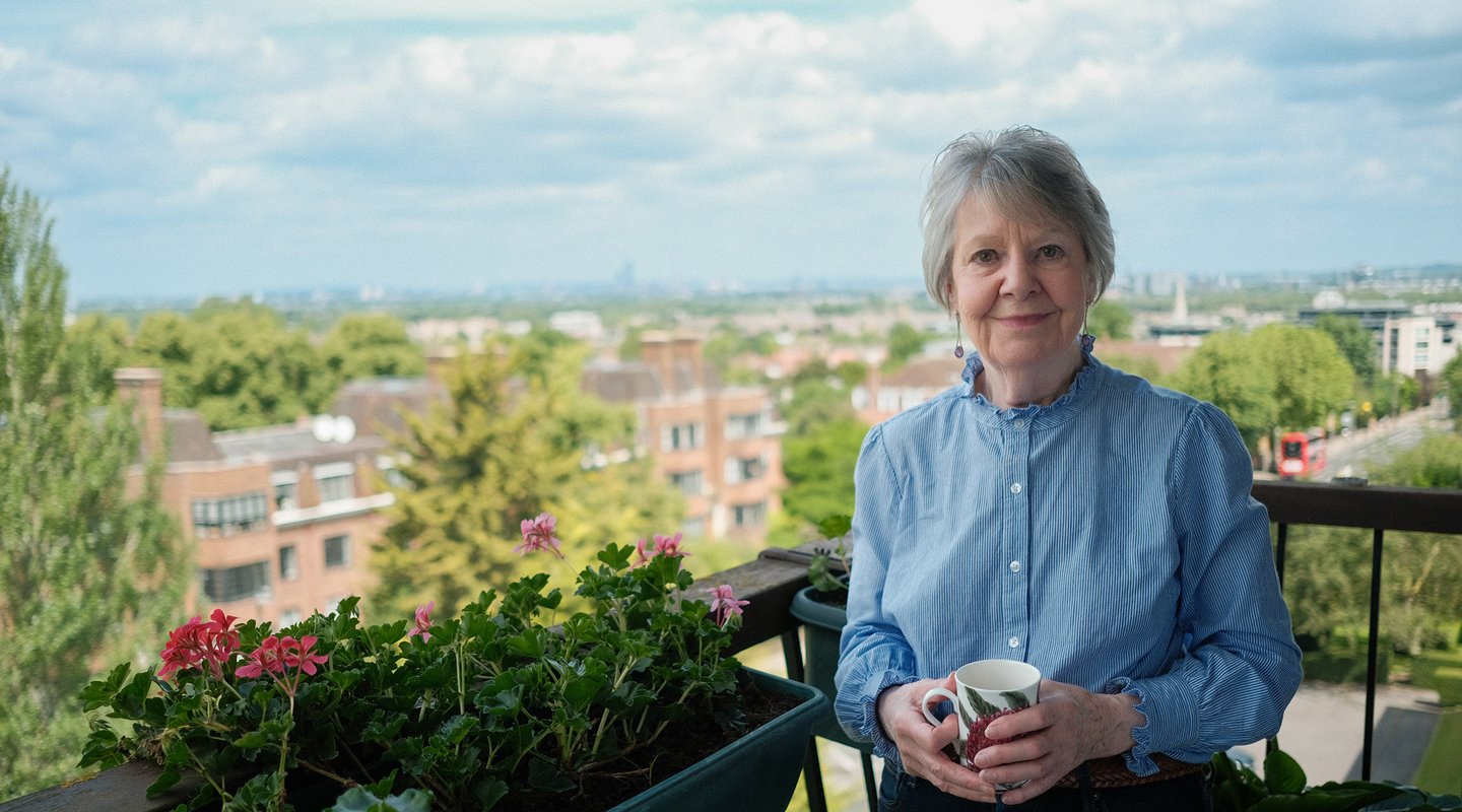 Oxfam Legacy Pledger Kate standing on the balcony of her home in London.