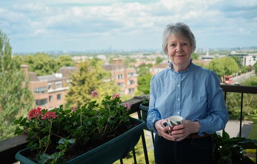 Oxfam Legacy Pledger Kate standing on the balcony of her home in London.