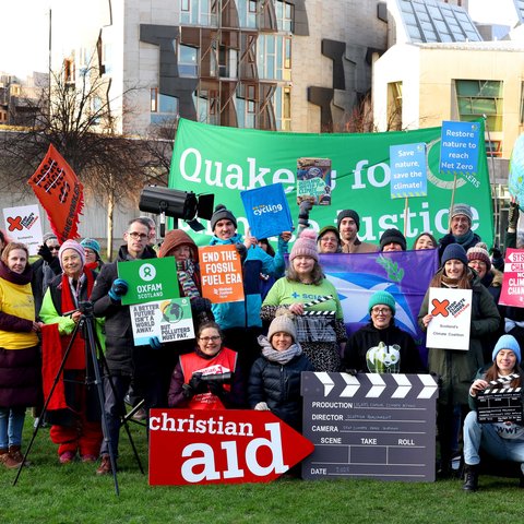 Climate campaigners with colourful banners outside the Scottish Parliament