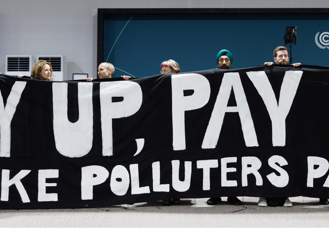 Activists are holding a giant banner at COP29 that says 'Pay up, Pay up, Make polluters pay'