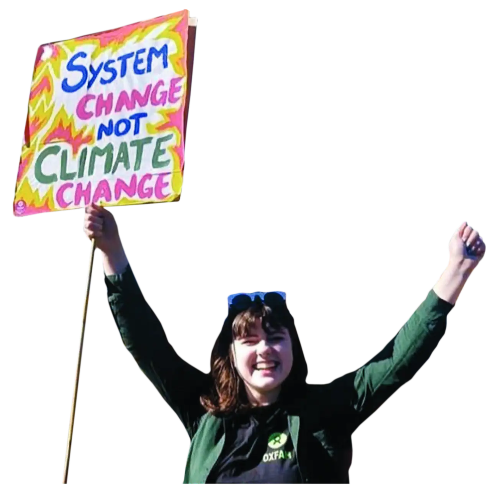 An Oxfam climate campaigner with a sign that says 'system change not climate change'