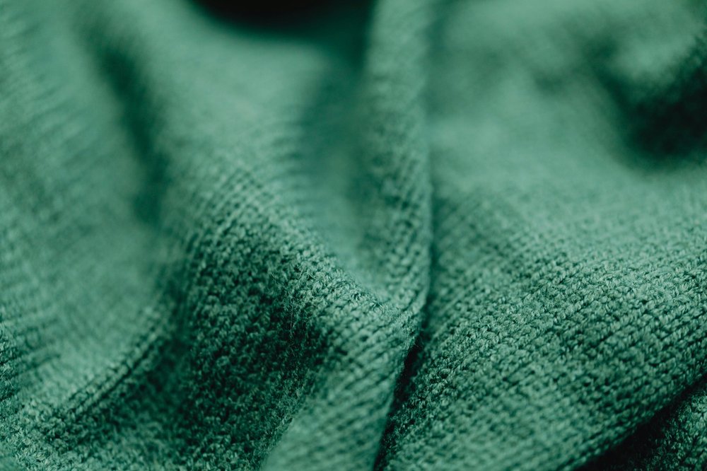 Close up of a dark green piece of fabric which has is made of cotton.