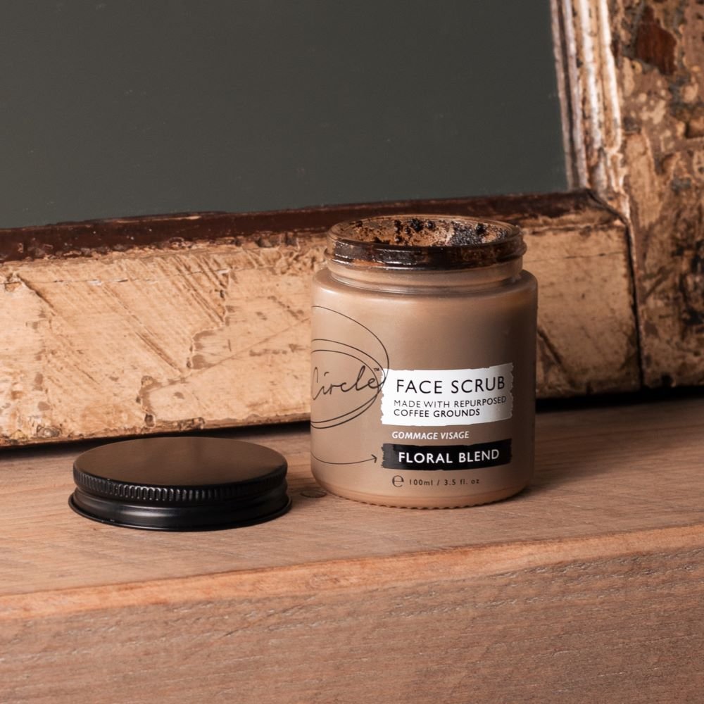coffee facial scrub skincare product open on wooden shelf infront of mirror