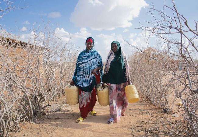 Hadija Jillo and Qali Chana, project participants in Hagarusu village in Isiolo County, on their way to fetch water.