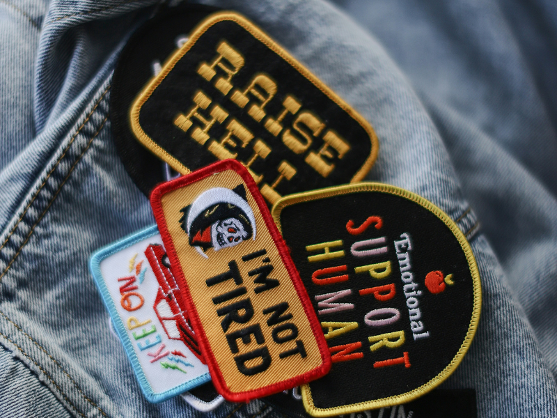 A collection of sewing patches lying on denim shirt