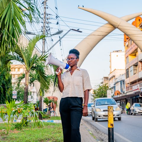Climate Activist Joyce Koech with a megaphone standing in the streets of Mombasa