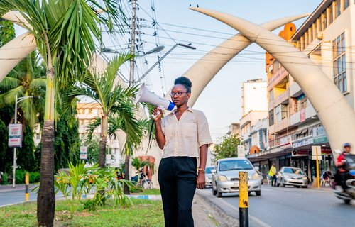 Climate Activist Joyce Koech with a megaphone standing in the streets of Mombasa