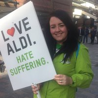 A picture of campaigner Kelly Mundy holding a sign that says 'love Aldi hate suffering'