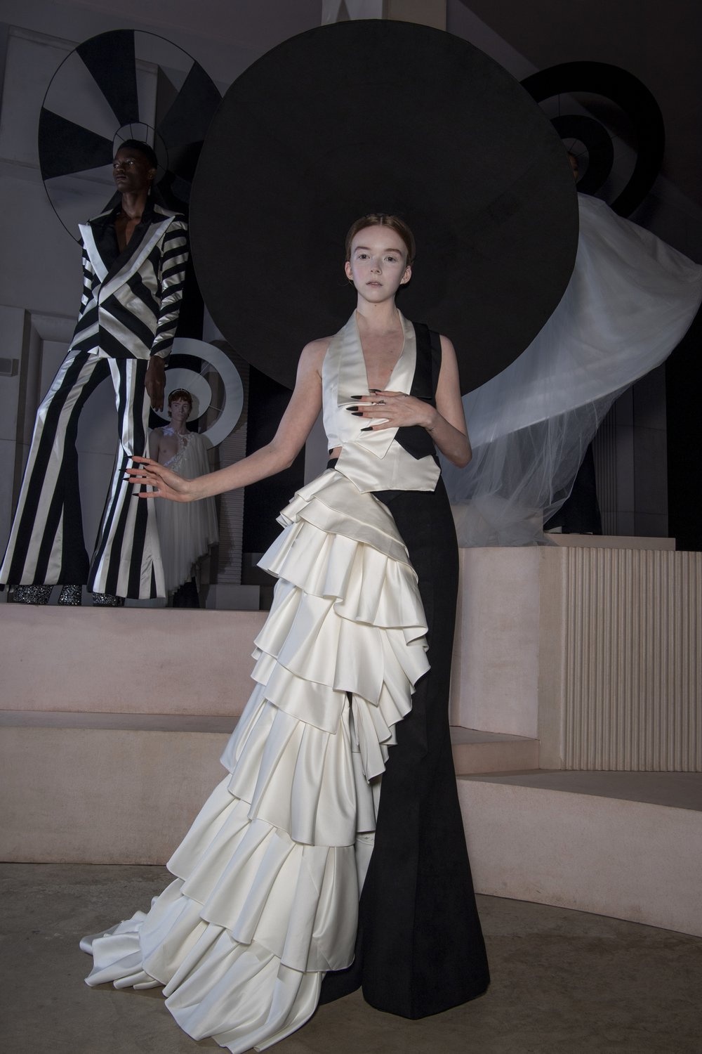 A model wears a demi-couture bridal gown made from Oxfam pre-loved bridal wear and a black halo.