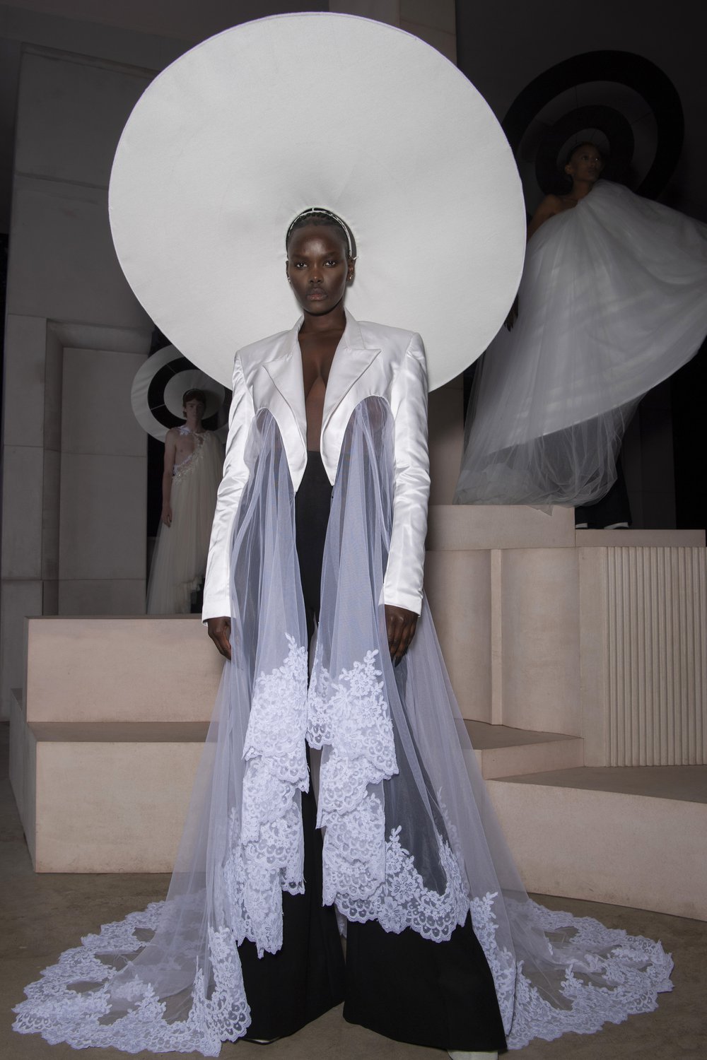 A model wears a demi-couture bridal gown made from Oxfam pre-loved bridal wear and a black halo.