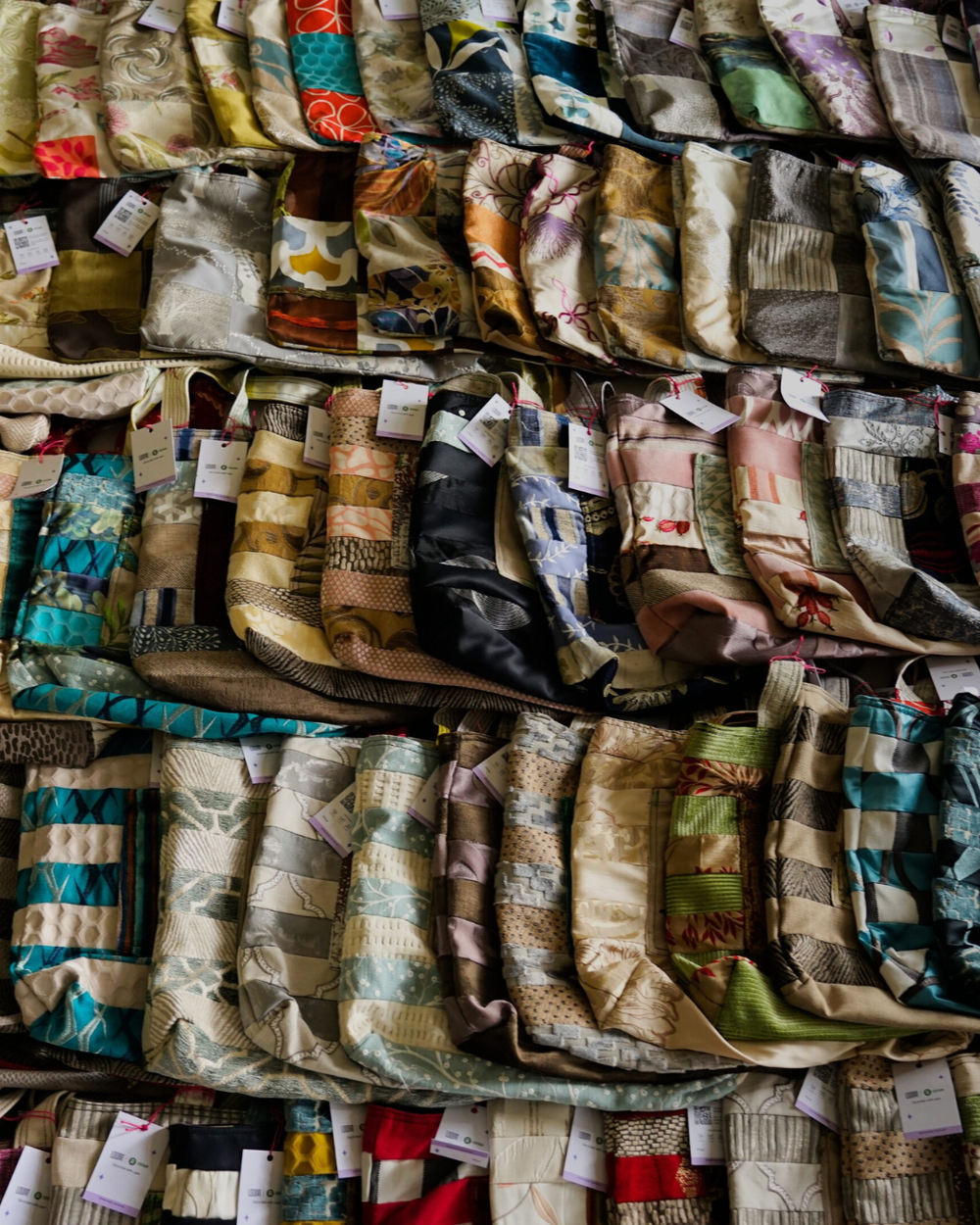 A image showing the selection of Loom bags, they are placed one by one to each other slightly overlapping. Each bag is unique with its own pattern made from different textiles.