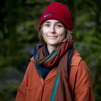 A profile picture of Lyndsay Walsh. Lyndsay is white and has short blondish hair and wears a red outdoor weather hat and a jacket.