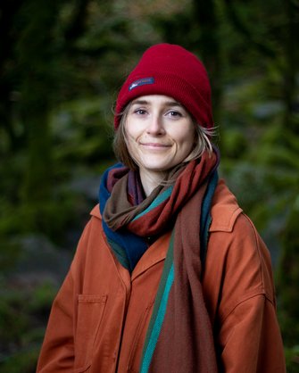 A profile picture of Lyndsay Walsh. Lyndsay is white and has short blondish hair and wears a red outdoor weather hat and a jacket.