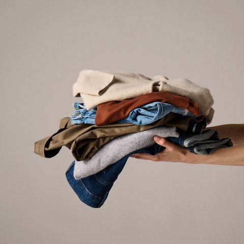 An image of someone holding a pile of clothes