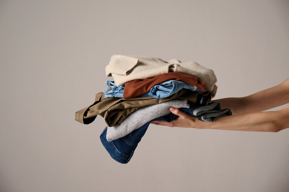 An image of someone holding a pile of clothes