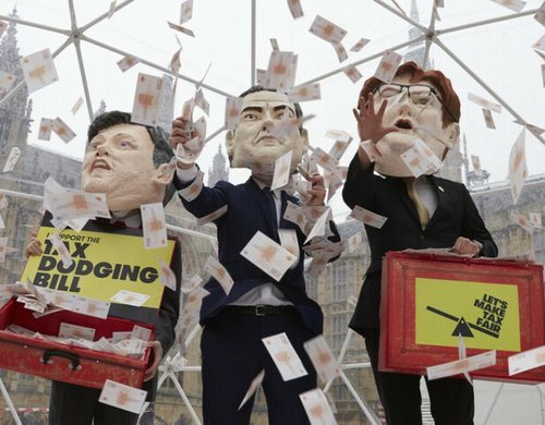 Campaigners from the Tax Dodging Bill campaign dressed up as George Osborne, Ed Balls and Danny Alexander, holding budget boxes to take part inside a cash grab inside a crystal maze style dome to represent the vast amounts of cash lost to tax dodging.