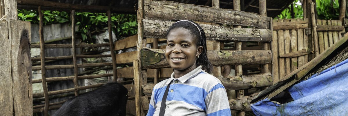 Marie Nsimire stands next to her pigs.