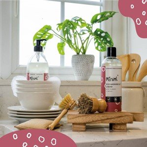 A kitchen side with a window lighting the room, in the centre of the image is Miniml products like washing liquid and hand wash.