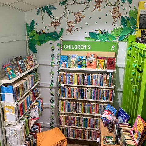 Oxfam Preston's children's books section with new monkey mural on the wall and a toget foot cushion on the floor