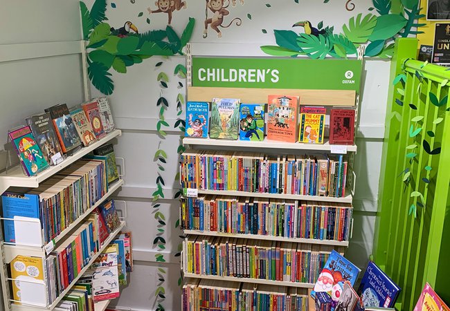 Oxfam Preston's children's books section with new monkey mural on the wall and a toget foot cushion on the floor