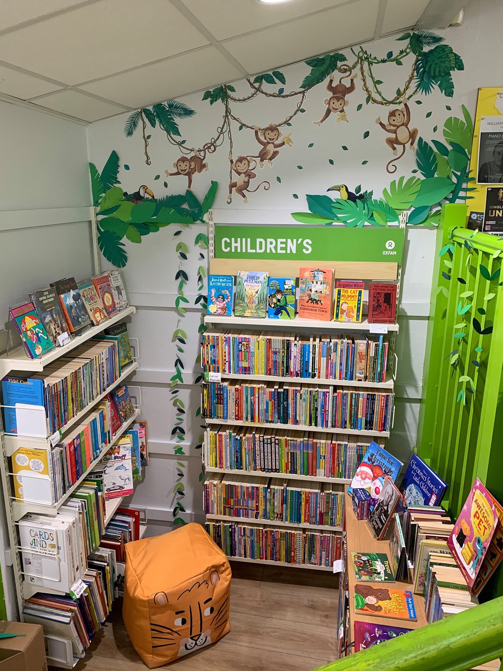 Oxfam Preston's children's books section with new monkey mural on the wall and a toget foot cushion on the floor