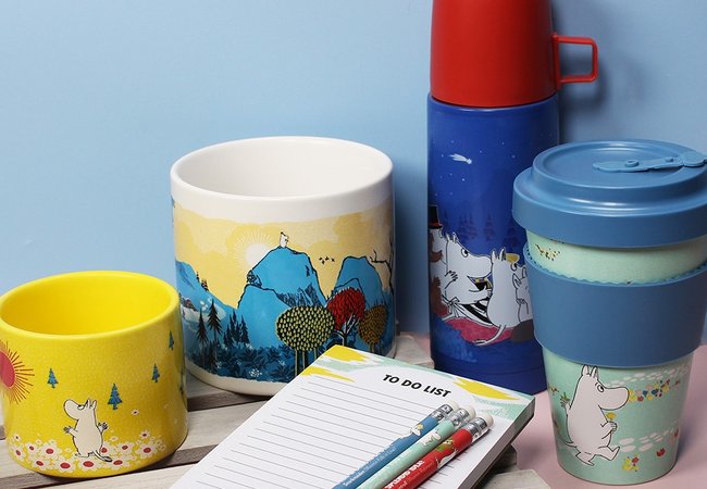 Collection of Moomin products exclusive to Oxfam including a plant pot, flask, travel mug, note pad and pencils
