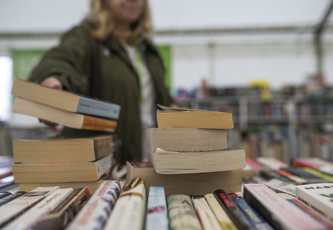 Someone reaches for a stack of books on a display