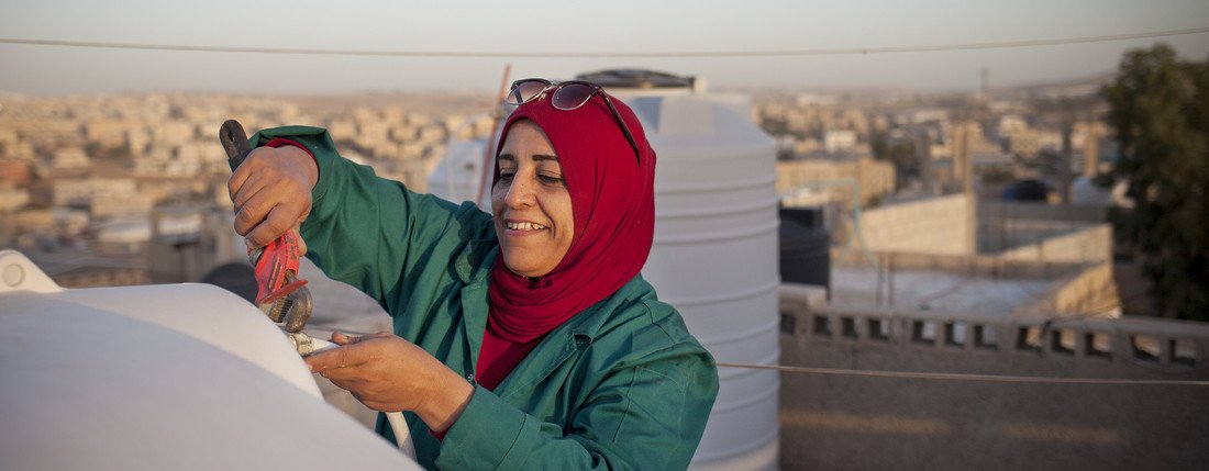 Mariam, a woman aged 44, is fixing the water tank on the rooftop of her house in the town of Zarqa in Jordan.