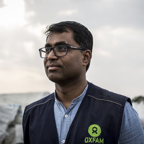 A portrait of Dhananjayan Sriskandarajah wearing a black Oxfam vest.