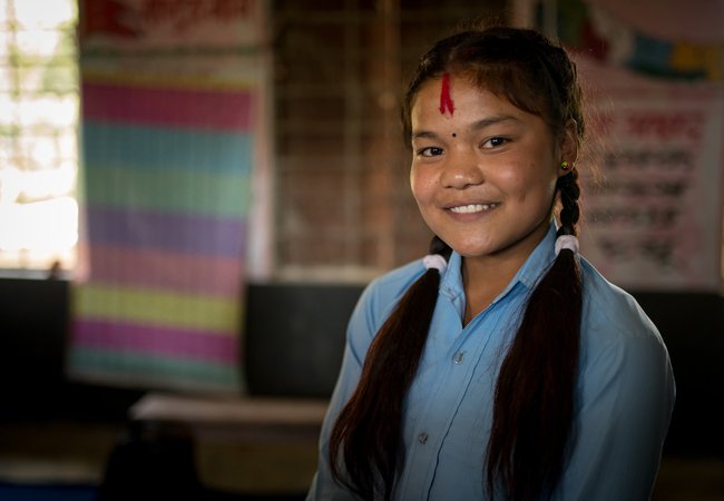 Reema* (15yrs) stands in a classroom in a village in Nepalgunj district, Nepal.